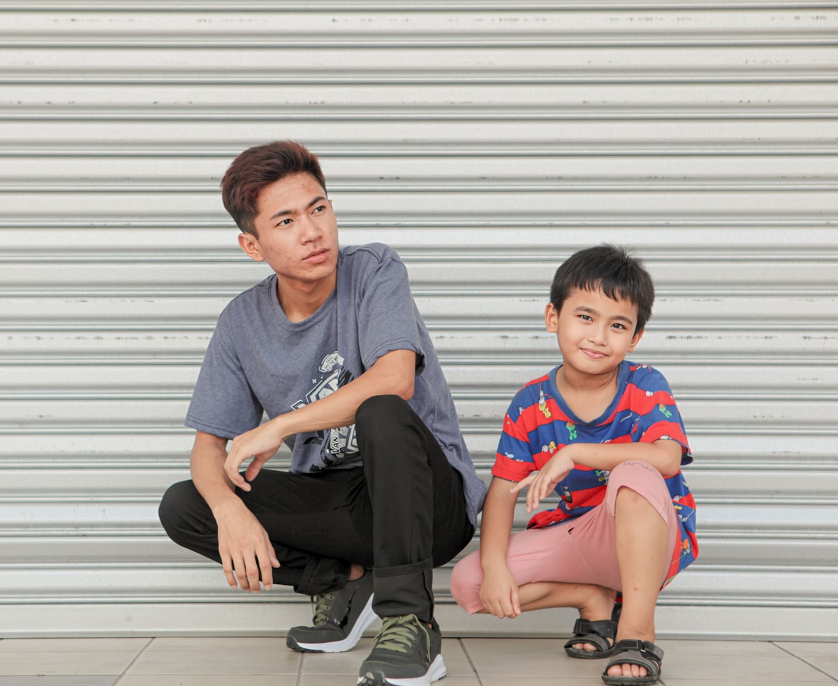 a man and a boy sitting on the ground