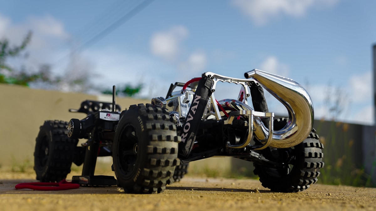 um caminhão de brinquedo com quatro rodas em uma estrada de terra